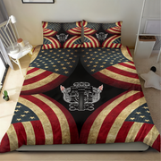 A bed dressed with a patriotic-themed bedding set featuring a distressed American flag pattern and a central black panel with a silver mechanical key graphic, shown in a bedroom setting.