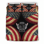 A bedding set featuring a duvet cover and two matching pillowcases with a symmetrical design of distressed American flags and a central metallic engine block graphic on a black background.