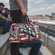 Person holding a colorful duffel bag with drag racing graphic designs in an outdoor setting.