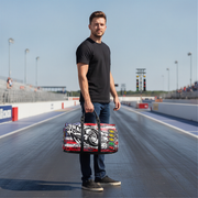 Man holding a drag racing duffel bag on a race track