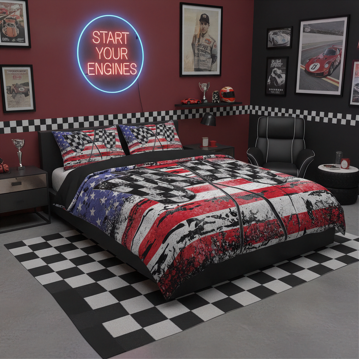 A bed dressed in a red, white, and blue American flag and black-and-white checkered print comforter set, styled in a dark garage-themed bedroom with a black-and-white checkered rug, racing posters, and a neon sign reading 'START YOUR ENGINES'.