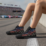 Woman wearing black high-top sneakers with racing design on a race track.