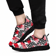 A pair of low-top sneakers with a vibrant, multicolored paisley and floral pattern in pink, purple, green, and blue, worn with black jogger pants against a plain white background.