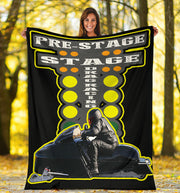 Woman holding a custom asphalt snowmobile blanket outdoors, showing a sample sled-and-rider photo beneath yellow-outlined drag starting lights.