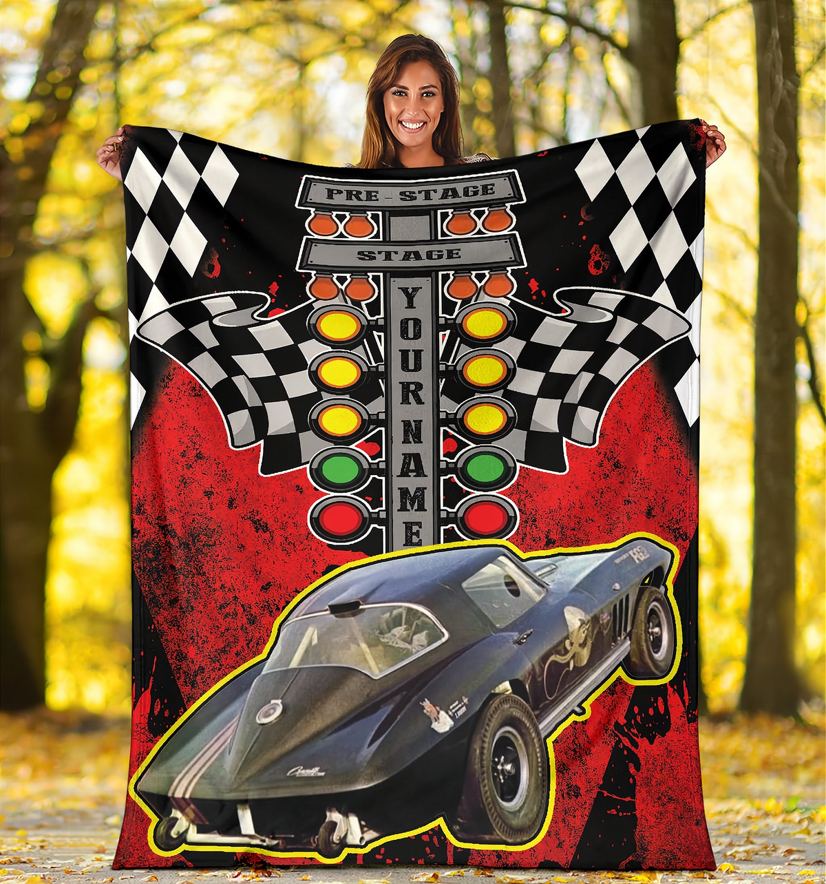 Woman holding a custom drag racing photo blanket outdoors among autumn trees, featuring a red background and drag tree design.