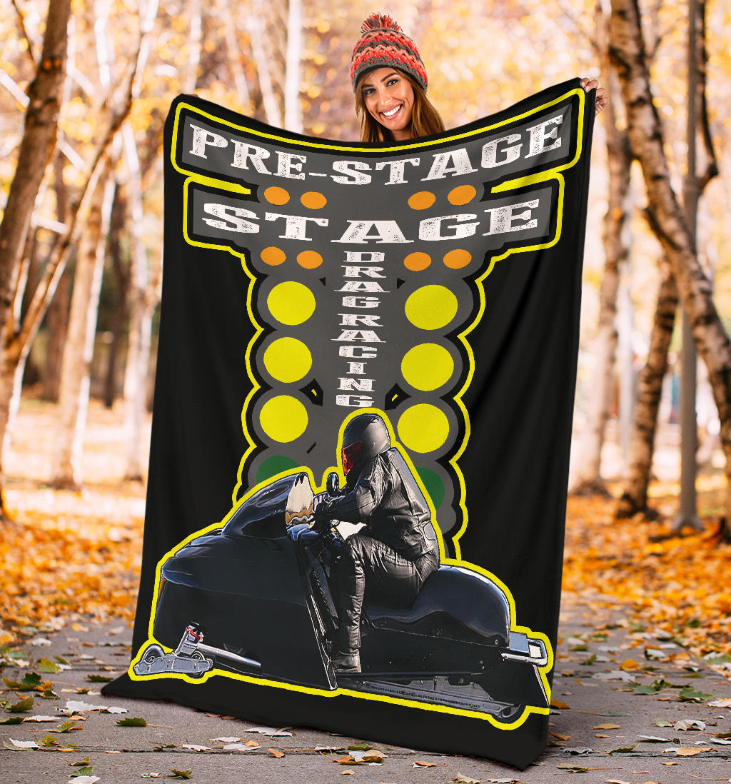 Woman in a knit hat holding the snowmobile asphalt blanket on an autumn path, displaying the full starting-tree and rider design.