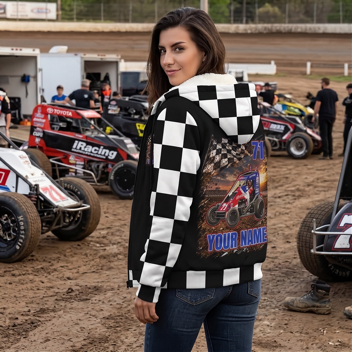 Woman in the racing pits showing the personalized midget car design on the back of her checkered sherpa jacket.