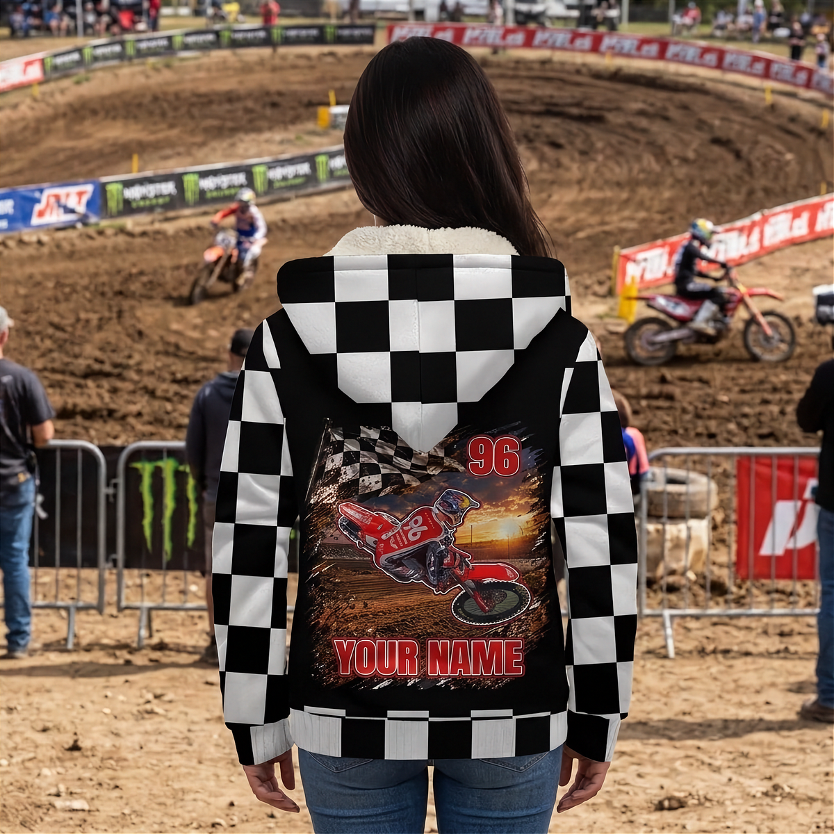 Woman watching motocross in a personalized dirt bike sherpa jacket, with rider artwork, number 96, and “YOUR NAME” on the back.