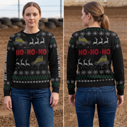 A woman modeling a black Christmas sweater with a green and white holiday pattern and red 'HO-HO-HO' text, shown in front and back views against an outdoor dirt lot background.