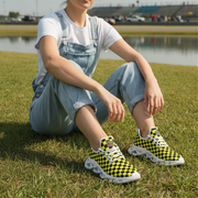 Woman wearing checkered shoes sitting on grass with a lake and stadium in the background