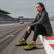 Woman sitting on a race track wearing checkered shoes