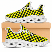 Checkered black and yellow sneakers with white soles on a beige box.