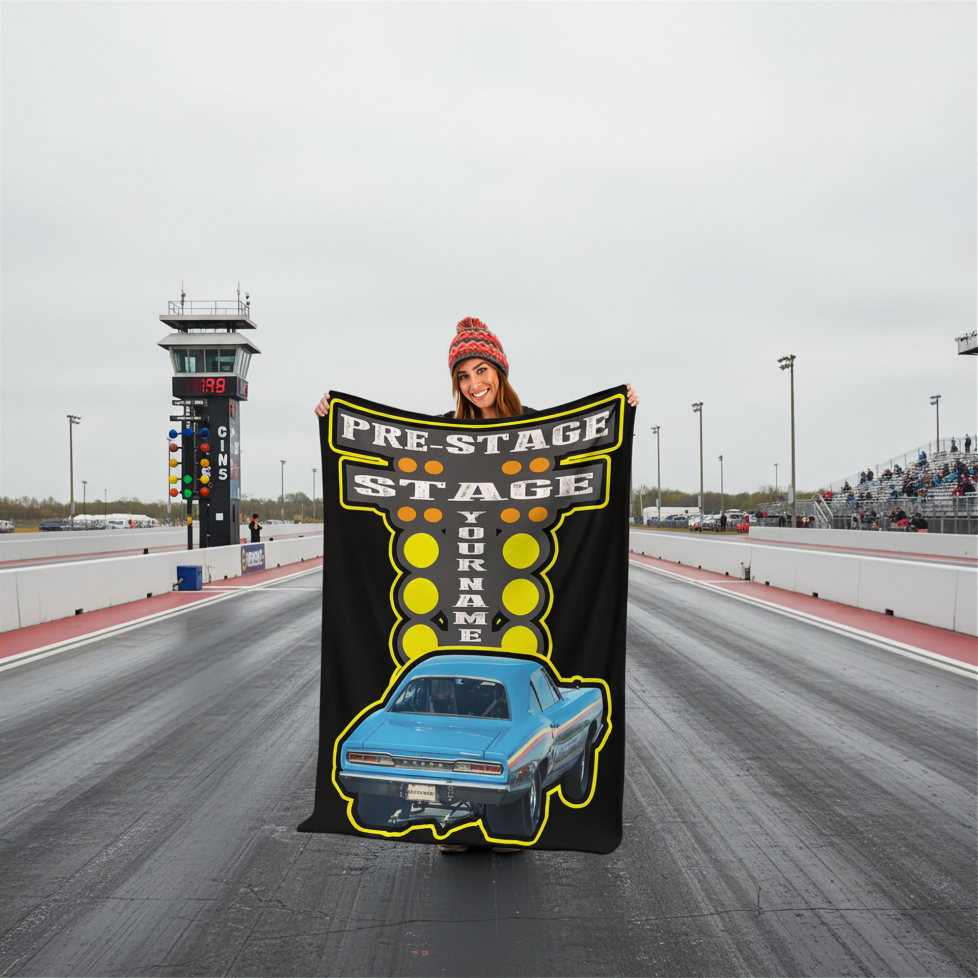 Person holding a custom drag racing  blanket with a race car design on a racetrack