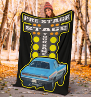 Person holding a large drag racing blanket with a car design and text in an autumn setting