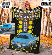 woman holding a blanket with a blue car design and customizable text, set against a natural background.
