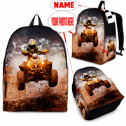 Custom personalized quad ATV backpack for kids featuring an off-road four-wheeler leaping over a muddy jump for back to school gear.