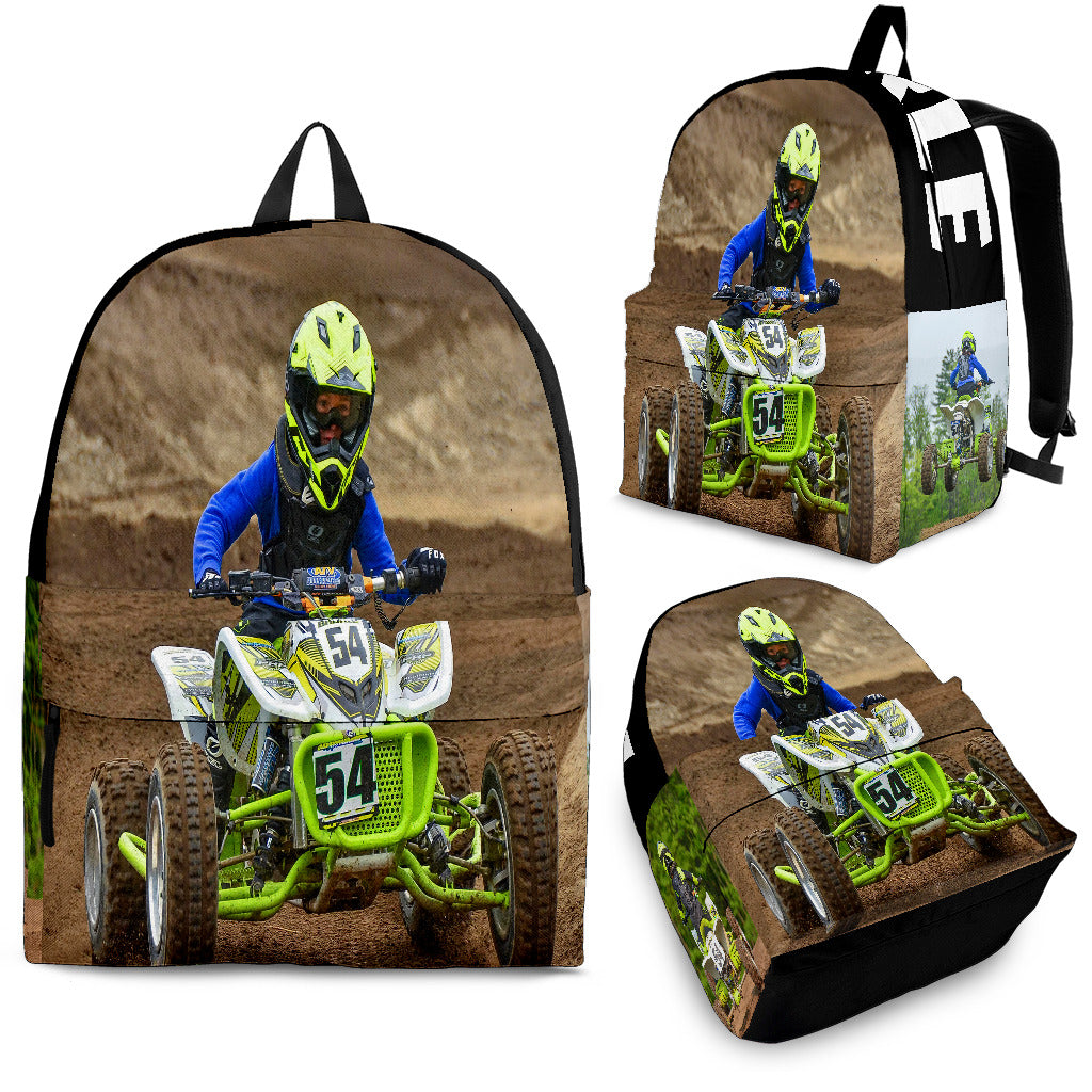 Custom personalized quad ATV backpack for kids featuring an off-road four-wheeler leaping over a muddy jump for back to school gear.