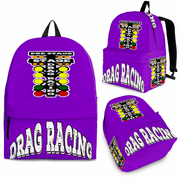 A drag racing fan wearing a bright purple motorsport backpack, standing behind the burnout box at a quarter-mile drag strip as thick white tire smoke fills the air under the stadium lights.