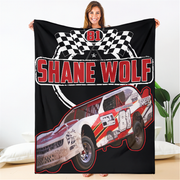 Person holding a blanket with a racing car design and 'Shane Wolf' text.