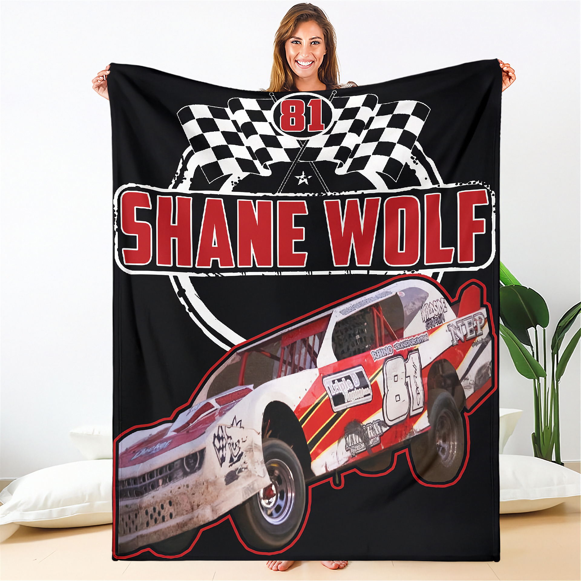 Person holding a blanket with a racing car design and 'Shane Wolf' text.