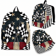 A racing fan carrying a patriotic USA checkered flag backpack walking past the ticket gates of a sprawling outdoor American speedway on a bright, sunny afternoon.