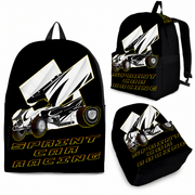 A passionate motorsport fan wearing a custom sprint car racing backpack, walking toward the busy pit gate of a local dirt track oval on a bright, sunny summer evening.