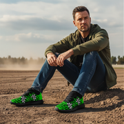 a man sitting at a dirt track wearing a black and green dirt racing sneakers