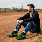 man sitting at a dirt track wearing a black and green checkered shoes