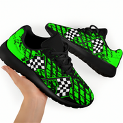 Black and green checkered patterned sneakers with a hand holding one shoe.