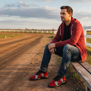 Man sitting on a wooden bench by a dirt road with a scenic background wearing dirt checkered sneakers