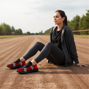 Woman sitting on a dirt track wearing black and red dirt racing checkered patterned shoes