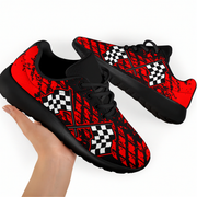Black and red checkered patterned sneakers held by a hand on a white background