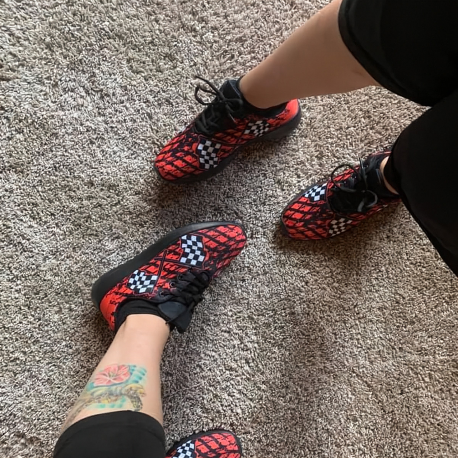 Red and black checkered shoes worn on a carpeted floor