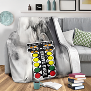 Gray marble-patterned blanket draped over a couch with a colorful 'Drag Racing' sign design.
