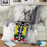Marble-patterned blanket with drag racing graphic draped over a chair in a living room.