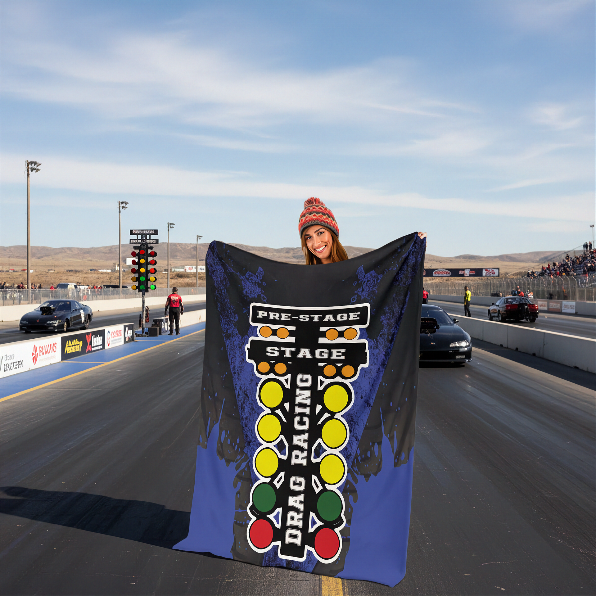 Person holding a 'Drag Racing' themed blanket on a race track