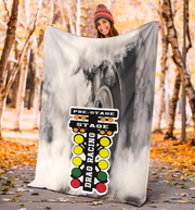 woman standing in the forest holding a drag racing blanket