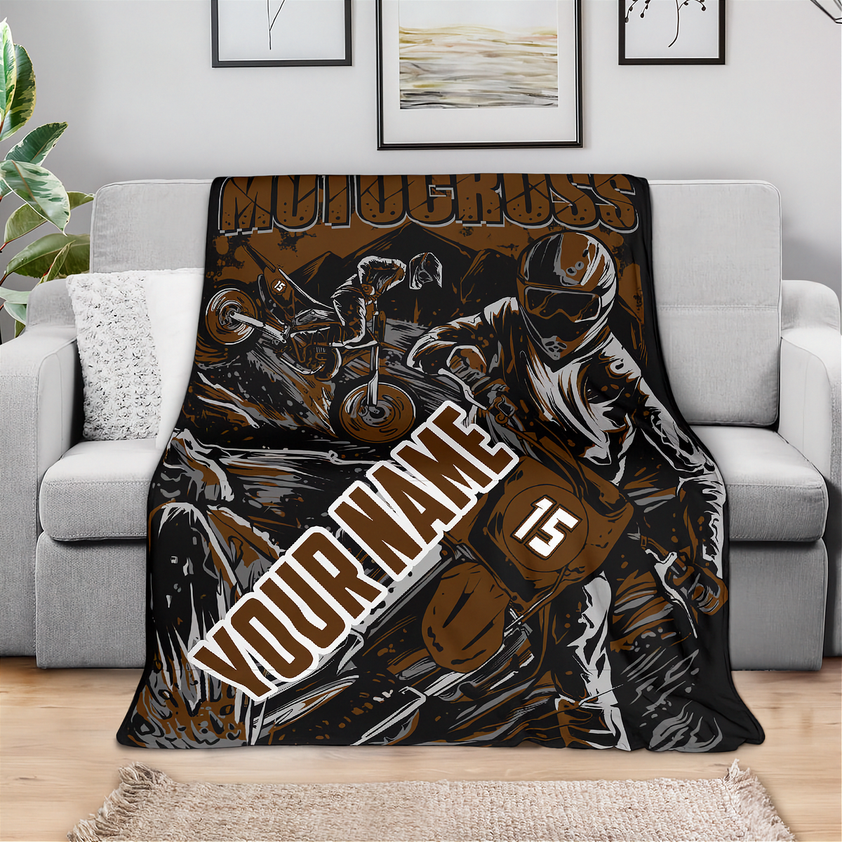 Front view of a brown and black custom motocross blanket draped over a light gray sofa, showing “Your Name” and number 15.