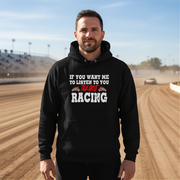 Man wearing a black hoodie with racing-themed text on a race track