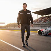 Man walking on a race track with a racing car in the background wearing a checkered flag low top shoes