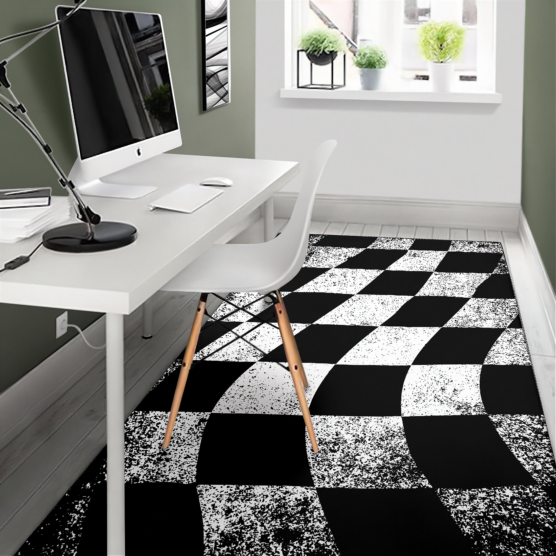 Modern office setup with a white desk, chair, and computer monitor on a black and white checkered rug.