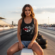 A trendy woman smiling while wearing a "Racing Checkered Lips" t-shirt and sunglasses, leaning against the side of a sleek sports car in a sunny outdoor parking lot.