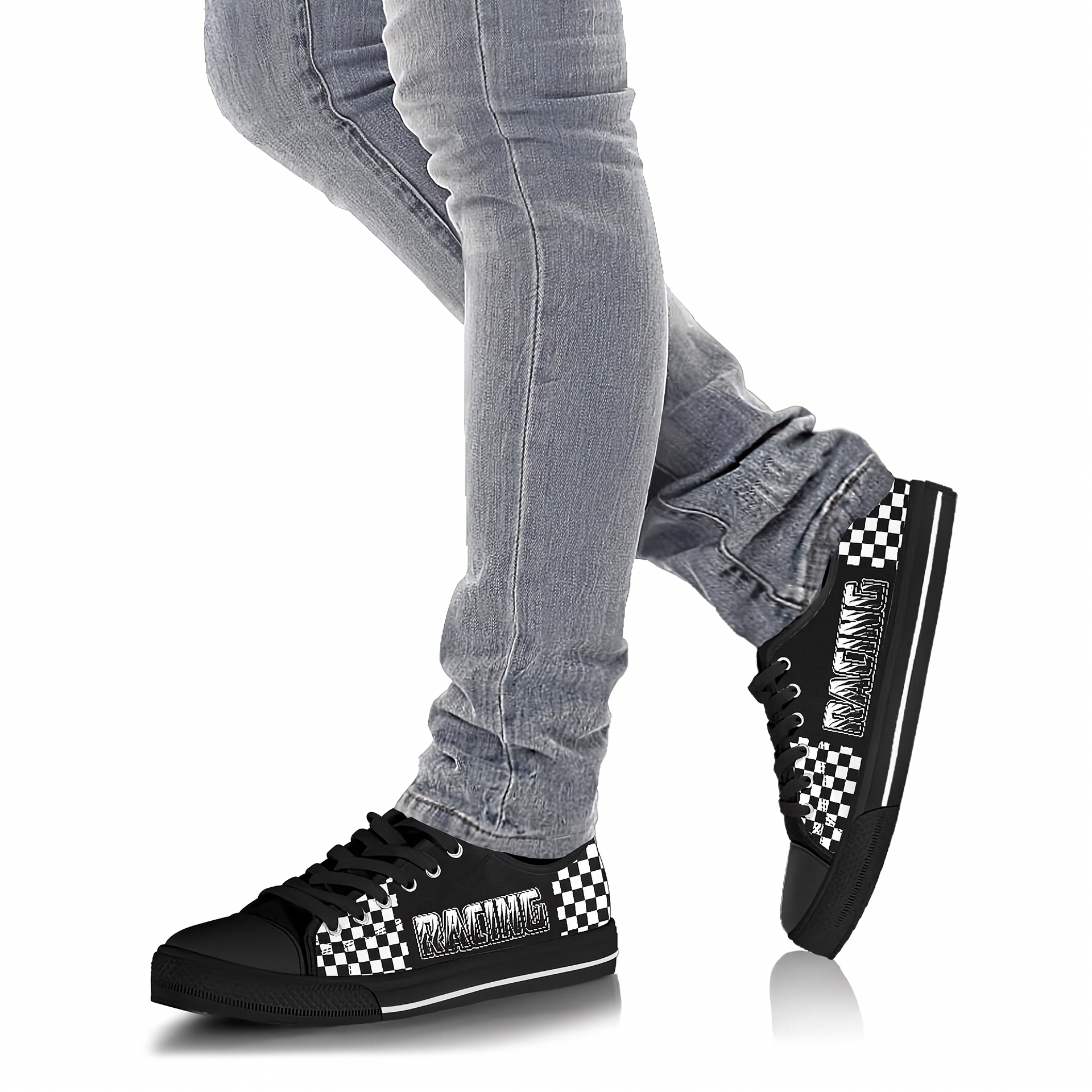 Black sneakers with checkered pattern worn with gray jeans on a white background