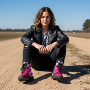 woman sitting in a dirt track wearing Pink racing checkered boots - motorsports vegan leather shoes