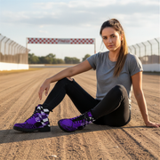 Woman sitting on a race track wearing purple boots with checkered pattern