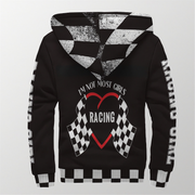 A stylish female race fan wearing the black "I'm Not Most Girls" sherpa jacket, with the hood up, standing under the bright LED lights of a racetrack grandstand, focusing on the textured lining and bold print.