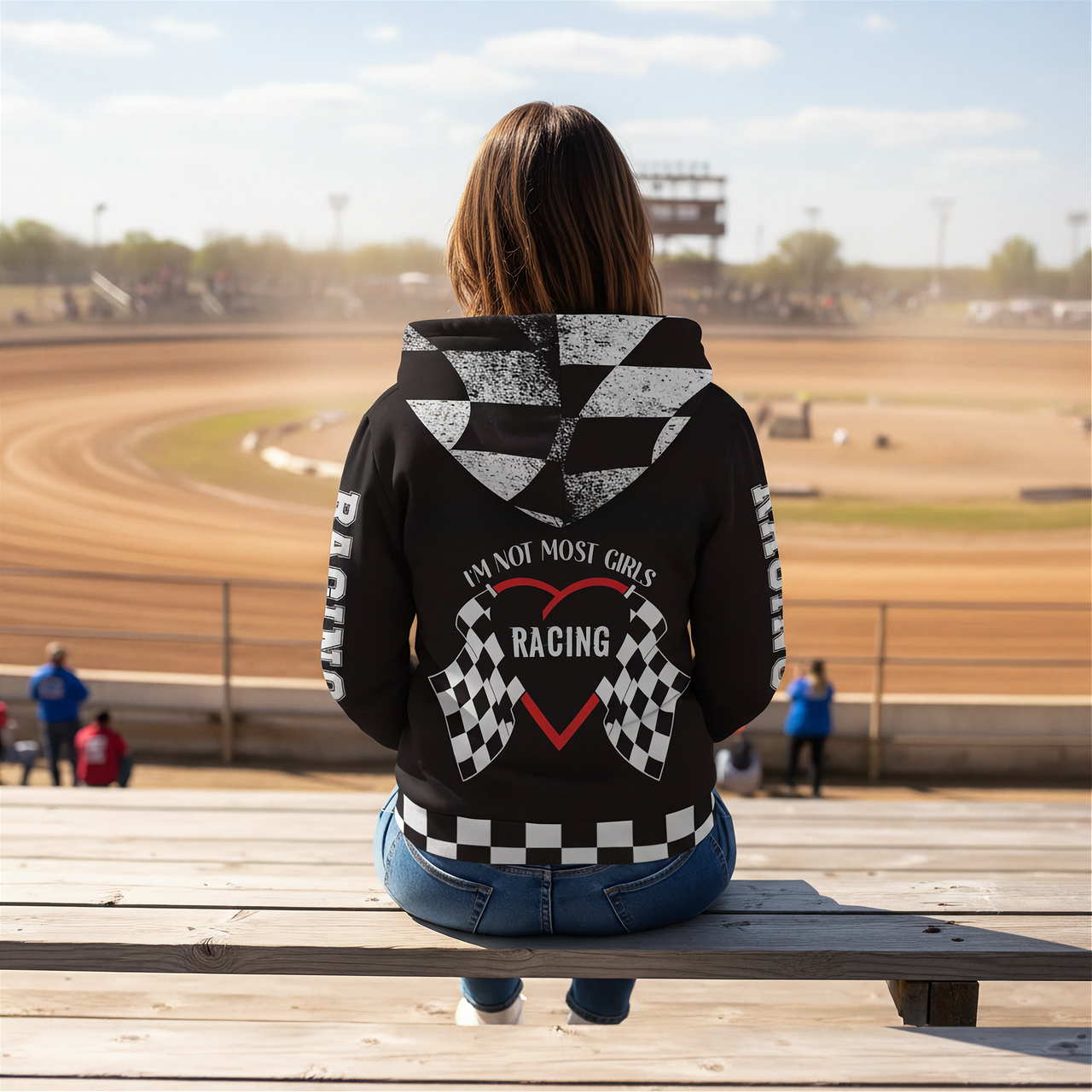 A stylish female race fan wearing the black "I'm Not Most Girls" sherpa jacket, with the hood up, standing under the bright LED lights of a racetrack grandstand, focusing on the textured lining and bold print.