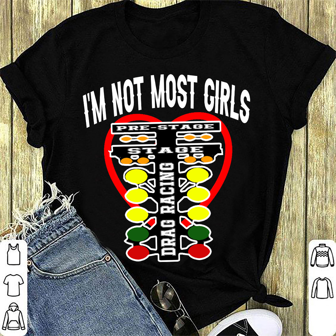 A bold and stylish apparel design featuring the text "I'm Not Most Girls" with drag racing graphics, printed on premium women's t-shirts, tanks, and hoodies.