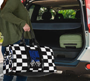 A stylish Racing Mom Travel Bag featuring a checkered flag pattern with the words "Racing Mom" and deep blue accents, carried by a model.