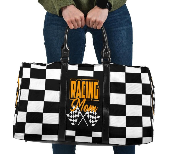 A stylish Racing Mom Travel Bag featuring a checkered flag pattern with the words "Racing Mom" and vibrant orange accents, carried by a model.